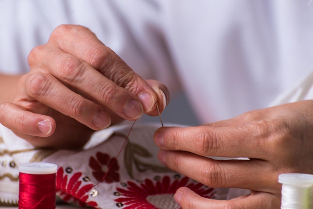 Руки мастера за работой с вышивкой